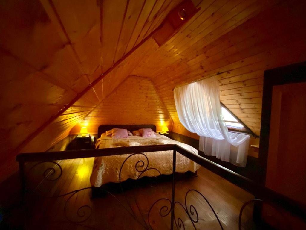 Potkrovlje brvnare sa krevetom i pogledom kroz prozor